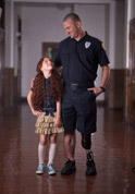 picture of policeman with prosthetic leg assisting a girl