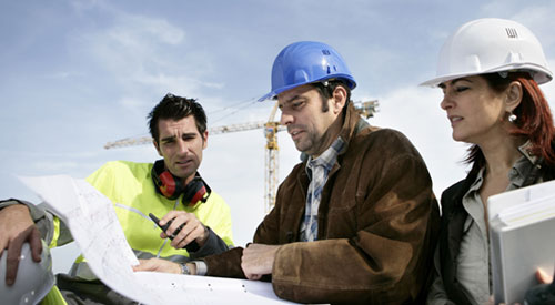 architect and construction workers reviewing drawings